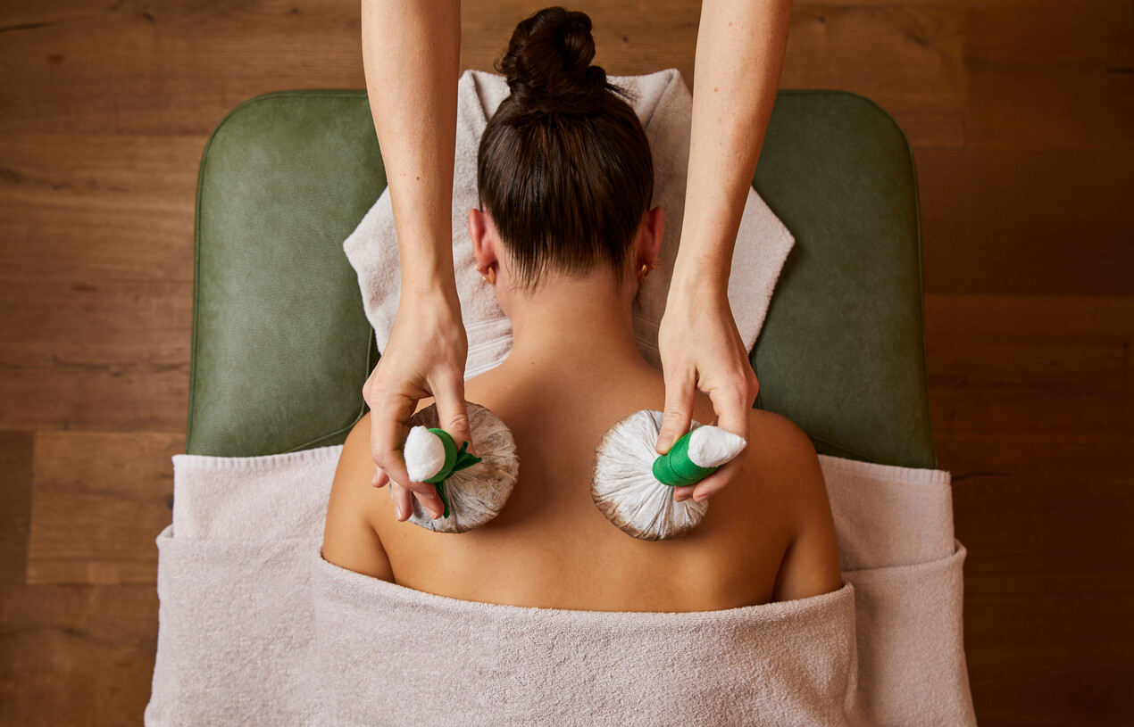 Wellness de luxe im Hotel Nesslerhof - Junge Dame bei einer Stempelmassage im Spa.