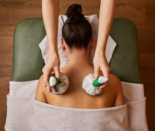 Wellness de luxe im Hotel Nesslerhof - Junge Dame bei einer Stempelmassage im Spa.