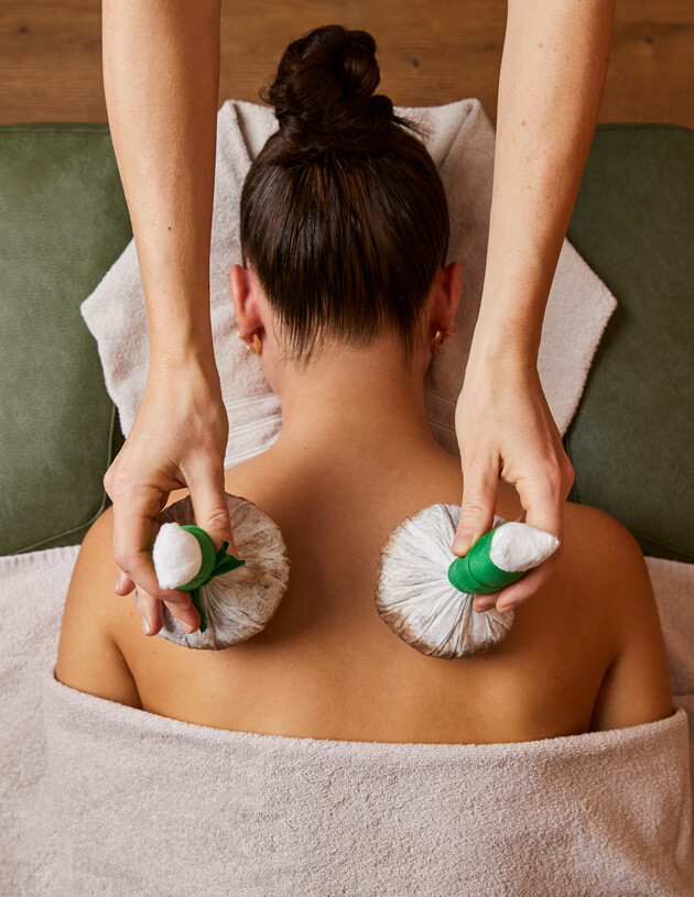 Wellness de luxe im Hotel Nesslerhof - Junge Dame bei einer Stempelmassage im Spa.