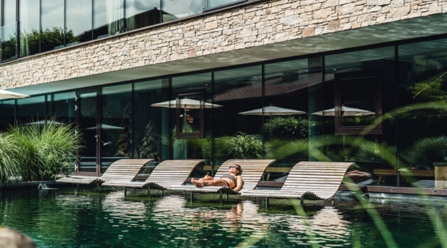 Woman is realxing on the wooden chair in the water