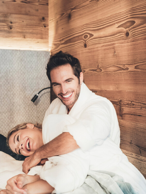 Ein Paar strahlt & lacht im Ruhebereich im Wellnesshotel Nesslerhof in Großarl